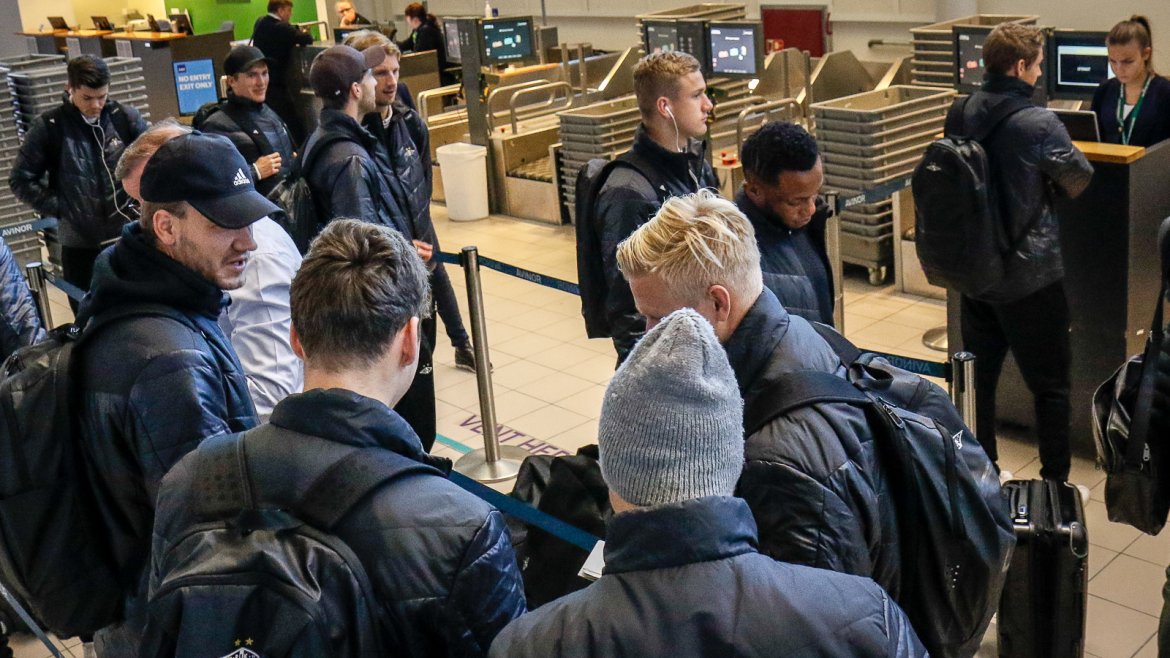 Laget står oppstilt på rekke for å sjekke inn til charterflyet som skal ta laget til Sankt Petersburg.